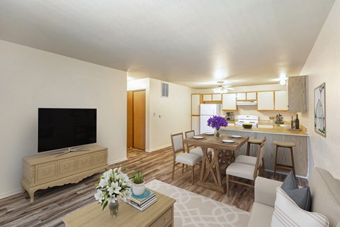 a living room and dining room with a table and chairs and a television